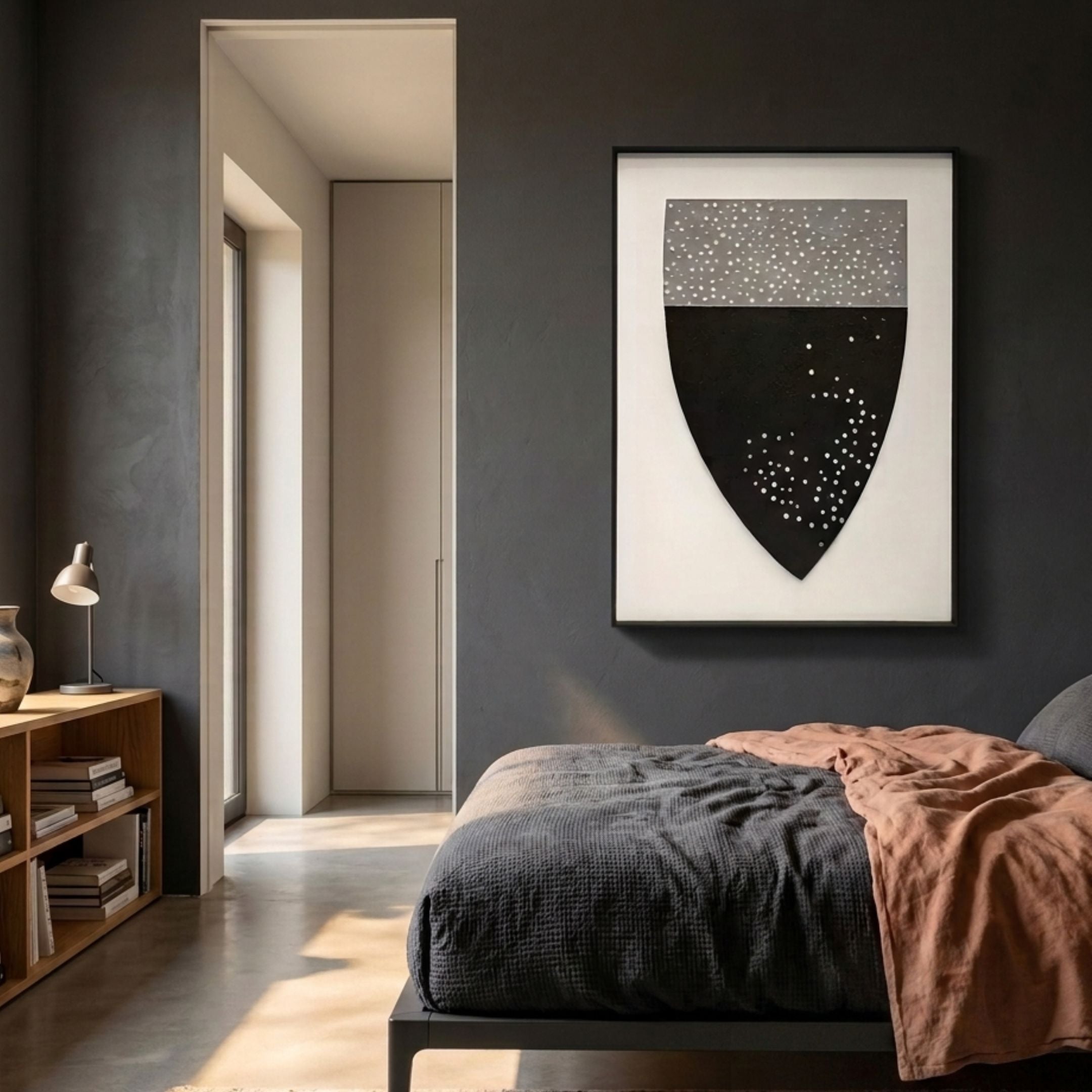 Noctara Crest Mist Monochrome Carved 3D Wall Art by Giant Sculptures, shield form with grey dotted upper half and matte black lower half, displayed above a bed.