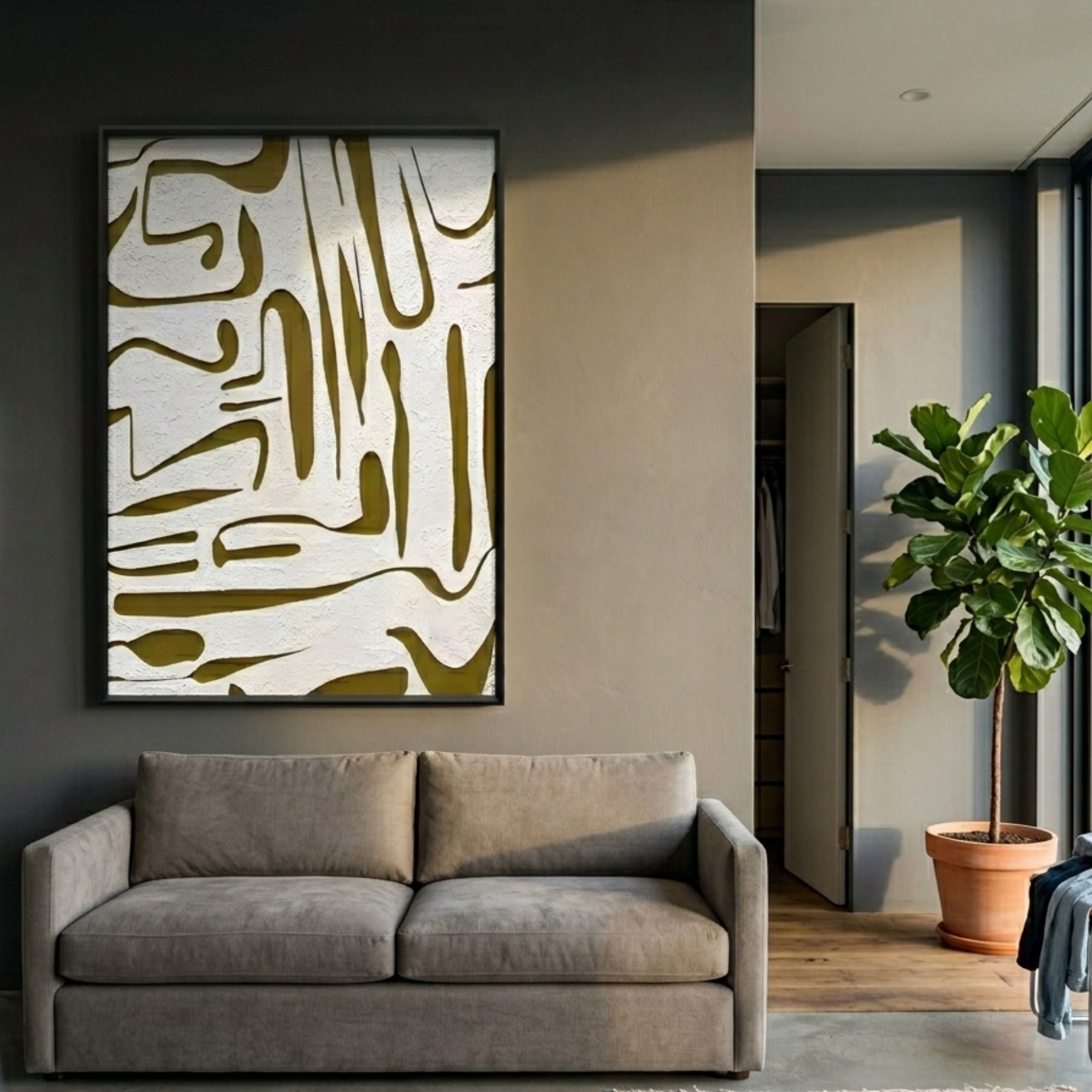 Dunari Olive Trace I Wood Carving 3D Wall Art with white organic cut-out shapes on a mustard ground in a slim black frame, mounted above a grey sofa beside a fiddle-leaf fig.