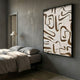 Dunari Earth Trace III Wood Carving 3D Wall Art with textured white surface and brown wood cut-outs in a black frame, mounted above a bed in a grey bedroom.