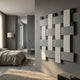 Tressel Interlock Fog Oil Painting 3D Wall Art by Giant Sculptures mounted on a grey wall in a modern bedroom with linen bedding and a floor lamp.