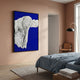 Ravelle Cobalt Contour Felt 3D Relief Wall Art with layered white wavy forms on cobalt blue, framed on a peach bedroom wall above a blue-linen bed.