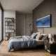 Flutine Deep Blue Wave Gradient Acrylic 3D Wall Art by Giant Sculptures displayed above a bed in a modern bedroom with a black bookshelf and wooden floor.