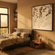 Pellora Multi-Colour Leather Scale 3D Wall Art by Giant Sculptures, framed in black and mounted above a linen bed with bookshelves and a warm-lit bedroom setting.