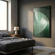 Cyclastra Green Optical Spiral Acrylic 3D Wall Art by Giant Sculptures mounted on a grey bedroom wall beside a wooden nightstand, lamp, and dark linen bed.