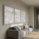 Nuvira White Triptych Swirl Leather 3D Wall Art by Giant Sculptures mounted above a blue and grey sofa in a modern living room with beige walls.
