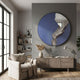 Rivelune Navy Blue Sculptural Round Mirror 3D Wall Art mounted on a grey wall above a wooden sideboard, beside a linen armchair and bookshelf.