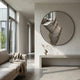 Rivelune Smoke Silver Sculptural Round Mirror 3D Wall Art mounted above a concrete bench in a minimalist living room with a beige sofa and pampas vase.