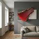 Valmeris Crimson Fold Sculptural Metal 3D Wall Art with gold-trimmed red iron arc on grey and ivory panels, mounted above a beige sofa in a modern living room.