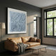 Calavine Blue Bloom Sculptural Leather 3D Wall Art in powdery blue with black frame, displayed above a tan leather sofa in a modern grey living room.