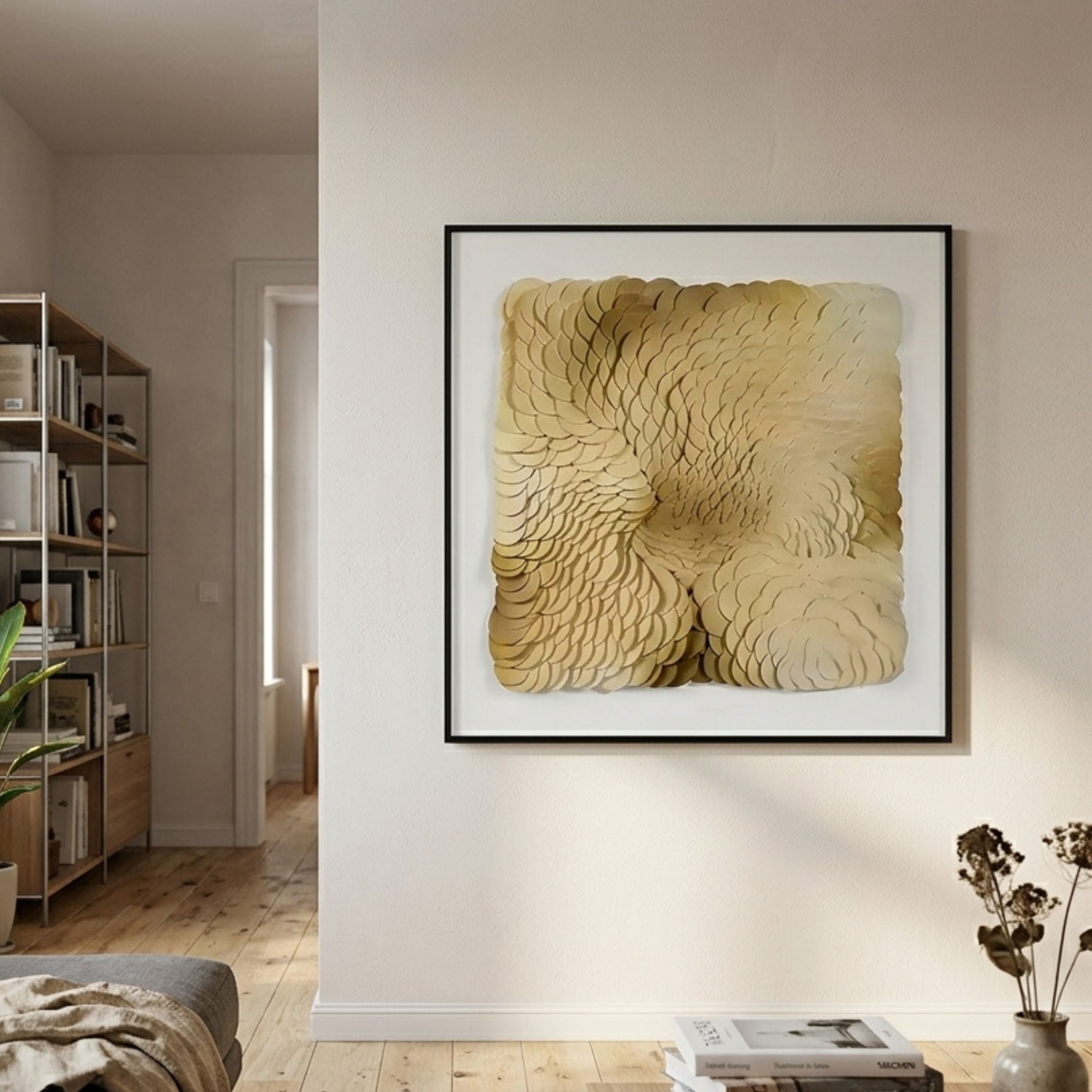 Calavine Sand Bloom Sculptural Leather 3D Wall Art in a slim black frame, displayed on a neutral living room wall beside a bookshelf and dried florals.