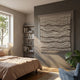 Tanglewave Ivory & Charcoal Ripple Texture Acrylic 3D Wall Art mounted on a taupe bedroom wall beside a bookshelf, linen bed, and monstera plant.