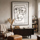 Linea Faces Minimal Acrylic UV 3D Wall Art by Giant Sculptures with black continuous-line abstract faces on white, displayed above a dark sideboard beside a bookshelf.