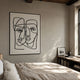 Linea Couple Faces Minimal Acrylic UV 3D Wall Art mounted above a linen-dressed bed in a sunlit bedroom with a low bookshelf beside a window.