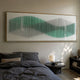 Harmoni Green Gradient Wave Acrylic 3D Wall Art mounted above a bed with grey linens, paper lantern lamp, and dark round side table in a modern bedroom.