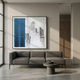 Urban Rise Blue Skyline Acrylic 3D Wall Art by Giant Sculptures displayed above a grey sofa in a minimalist living room with concrete floor and round side table.