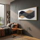 Harmoni Black & Tan Gradient Wave Acrylic 3D Wall Art in a gold frame, displayed above a modern bedroom with rust and grey bedding and a wooden side table.