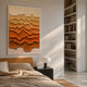 Cascade Rosewood Fade Paper 3D Wall Art by Giant Sculptures with layered torn paper in cream to burnt orange tones, displayed above a wooden bed beside a bookshelf.