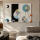 Orbit Multicolor Geometric Acrylic 3D Wall Art by Giant Sculptures with blue, yellow, white, and orange discs and spheres above a beige sofa.
