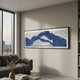 Waveform Blue Ripple Acrylic 3D Wall Art by Giant Sculptures in a thin black frame, mounted above a grey sofa in a modern living room with a city-view window.