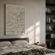 Petalwave Beige Ripple Cluster Leather 3D Wall Art by Giant Sculptures displayed above a linen-dressed bed beside a dark bookshelf in a warm neutral bedroom.