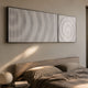 Luna I Spiral Illusion Flow Acrylic 3D Wall Art by Giant Sculptures, two black-framed white fin panels revealing a spiral vortex, mounted above an upholstered bed.