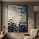 Tidefall Midnight Blue Waters Acrylic & Crystal Beads 3D Wall Art by Giant Sculptures, framed above a beige armchair in a warm neutral living room.