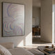 Lustra Iridescent Feather Motion Acrylic 3D Wall Art by Giant Sculptures in a black frame, displayed on a neutral wall in a sunlit modern living room.