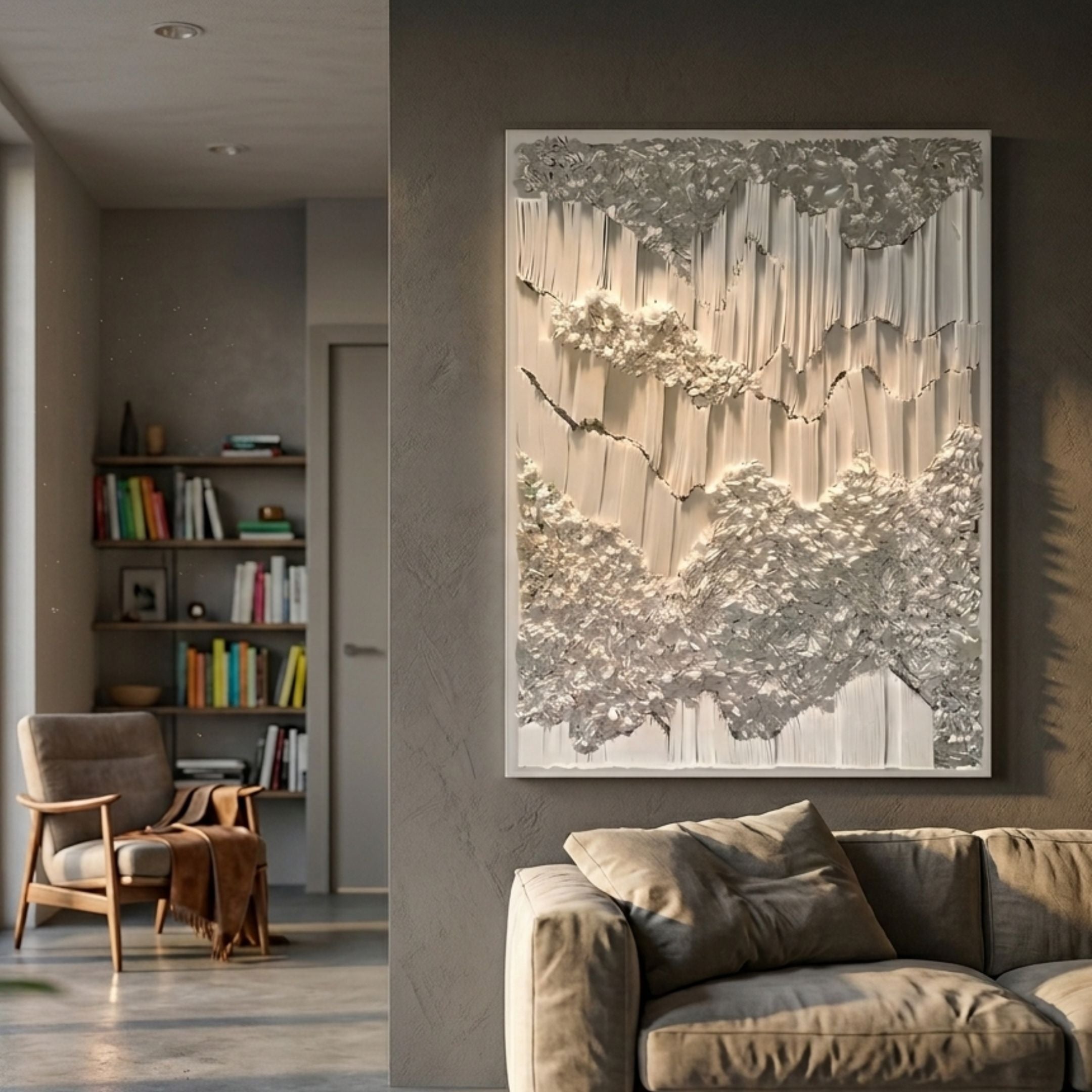 Tessara Ivory Organic Ripple Relief Felt 3D Wall Art mounted in a modern living room with a beige sofa, armchair, and bookshelf nearby.
