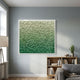 Bloom Mint & Emerald Green Curved Petal Acrylic 3D Wall Art in a white frame, displayed above an oak bookshelf in a grey-walled living room with floor lamp.
