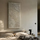 Vermira Ivory II Textured Leather 3D Metal Framed Wall Art mounted above a linen-dressed bed with a black mushroom lamp on a stone nightstand.