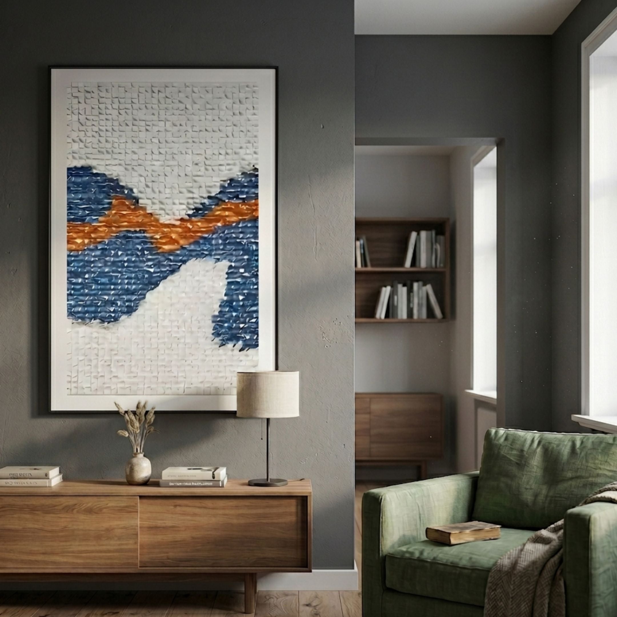 Wave Cobalt Blue & Rust Orange Acrylic 3D Wall Art in a black frame above a wooden console with lamp, beside a green armchair in a grey living room.