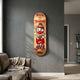 Kuman Boy Deck Vol.2 Skateboard Wall Art by Giant Sculptures, featuring a masked cartoon figure in red with gold chains and cash, mounted on a grey living room wall.