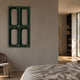 Lineris Green Glossy Wood Relief 3D Wall Art by Giant Sculptures mounted on a beige bedroom wall beside a linen-dressed bed and dark wood shelving.
