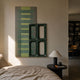 Lineris Green Oil Painting & Glossy Wood Relief 3D Wall Art mounted above a bedside table with lamp, beside a linen bed in a sunlit bedroom.