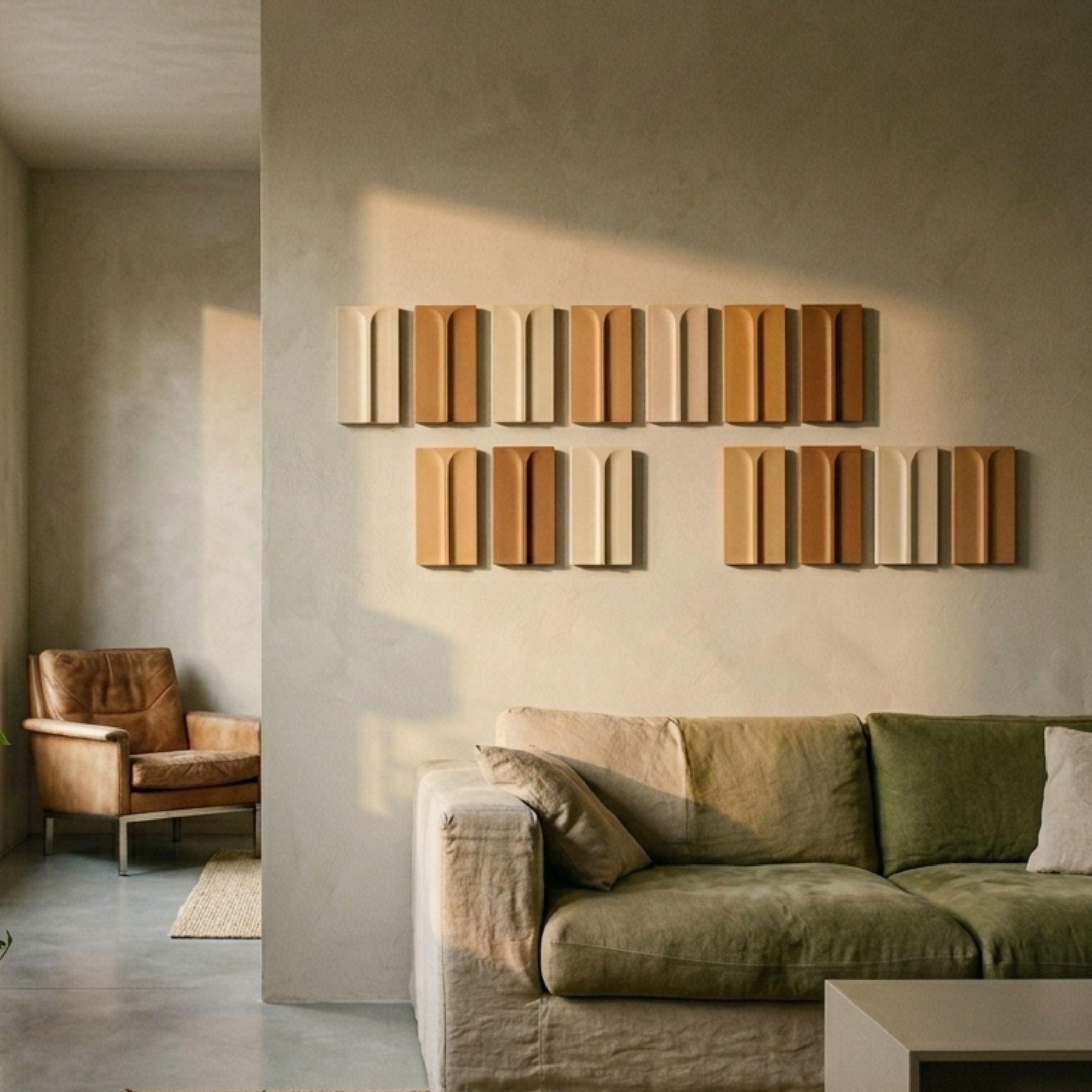 Eximia Earthy Tones Multi-Panel Wood Relief 3D Wall Art mounted in two rows above a green linen sofa, with a tan leather armchair in an adjoining room.