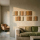 Eximia Earthy Tones Multi-Panel Wood Relief 3D Wall Art mounted in two rows above a green linen sofa, with a tan leather armchair in an adjoining room.