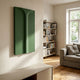 Eximia Green Minimalist Wood Relief 3D Wall Art with layered arch and column forms in sage to forest tones, mounted in a sunlit living room beside a bookshelf.