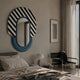 Arcus Blue & Black-White Striped Mirror 3D Wooden Wall Art mounted above a bed in a modern bedroom with a leather chair and table lamp nearby.