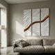 Evolva 3-Panel White & Gold Wood Relief 3D Wall Art by Giant Sculptures, mounted above a linen sofa beside a floor lamp in a neutral living room.