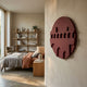 Arcuza Burgundy II Wood Carving Sandstone 3D Wall Art by Giant Sculptures mounted on a cream wall beside a bedroom with linen bedding, oak shelving and a reading chair.