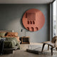 Arcuza Rose I Wood Carving Sandstone 3D Wall Art by Giant Sculptures, a rose-toned circular relief with vertical slats and arched recesses, mounted in a grey bedroom.