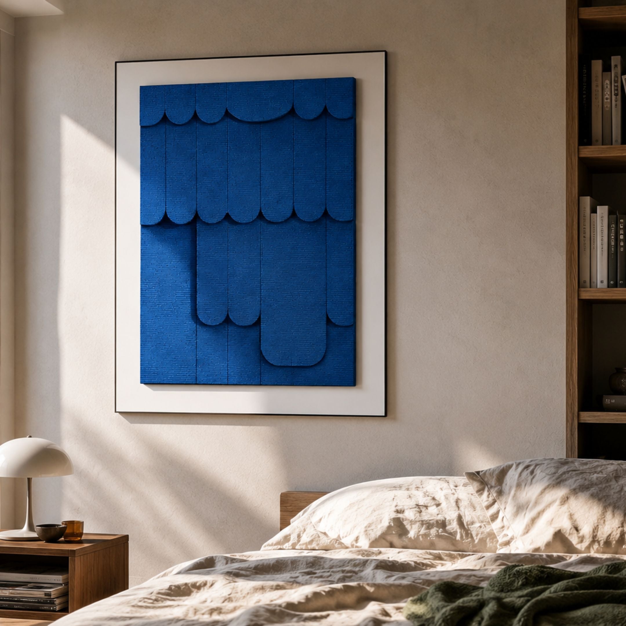 Cascala Blue Layered Wood Carving 3D Wall Art by Giant Sculptures, framed above a wooden bed with cream linens, beside a bookshelf and lamp-lit nightstand.