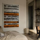 Rhythm Tangerine & Silver Layered Stripe Leather 3D Wall Art by Giant Sculptures mounted above a linen bed in a minimalist bedroom with cane chair.