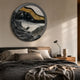 Auroria Rustic Horizon Hand-Painted Wood Relief 3D Wall Art by Giant Sculptures, circular black, gold, and white landscape piece above a bed with grey linens.