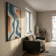 Marea Organic Flow Aqua & Copper Wood Relief 3D Wall Art with teal and bronze wavy contours in a black frame, hung above a grey sofa beside a window.