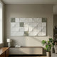 Averra White & Sage Grid Block Wood Relief 3D Wall Art by Giant Sculptures mounted above a low cabinet with lamp, books, and monstera plant in a modern living room.