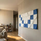 Averra White & Blue Geometric Wood Relief 3D Wall Art by Giant Sculptures mounted on a cream wall in a modern living room with bookshelf and sofa nearby.