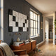 Averra White & Black Geometric Wood Relief 3D Wall Art by Giant Sculptures mounted on a dark grey wall above a mid-century teak sideboard beside a window.