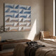 Elysia Geometric Cool Gradient Wood Relief 3D Wall Art by Giant Sculptures mounted in a neutral bedroom above a wooden bench, beside a cane chair.