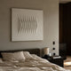 Ondara Wave White Square Wood Relief 3D Wall Art by Giant Sculptures displayed above a dark upholstered bed with linen bedding in a warm minimalist bedroom.